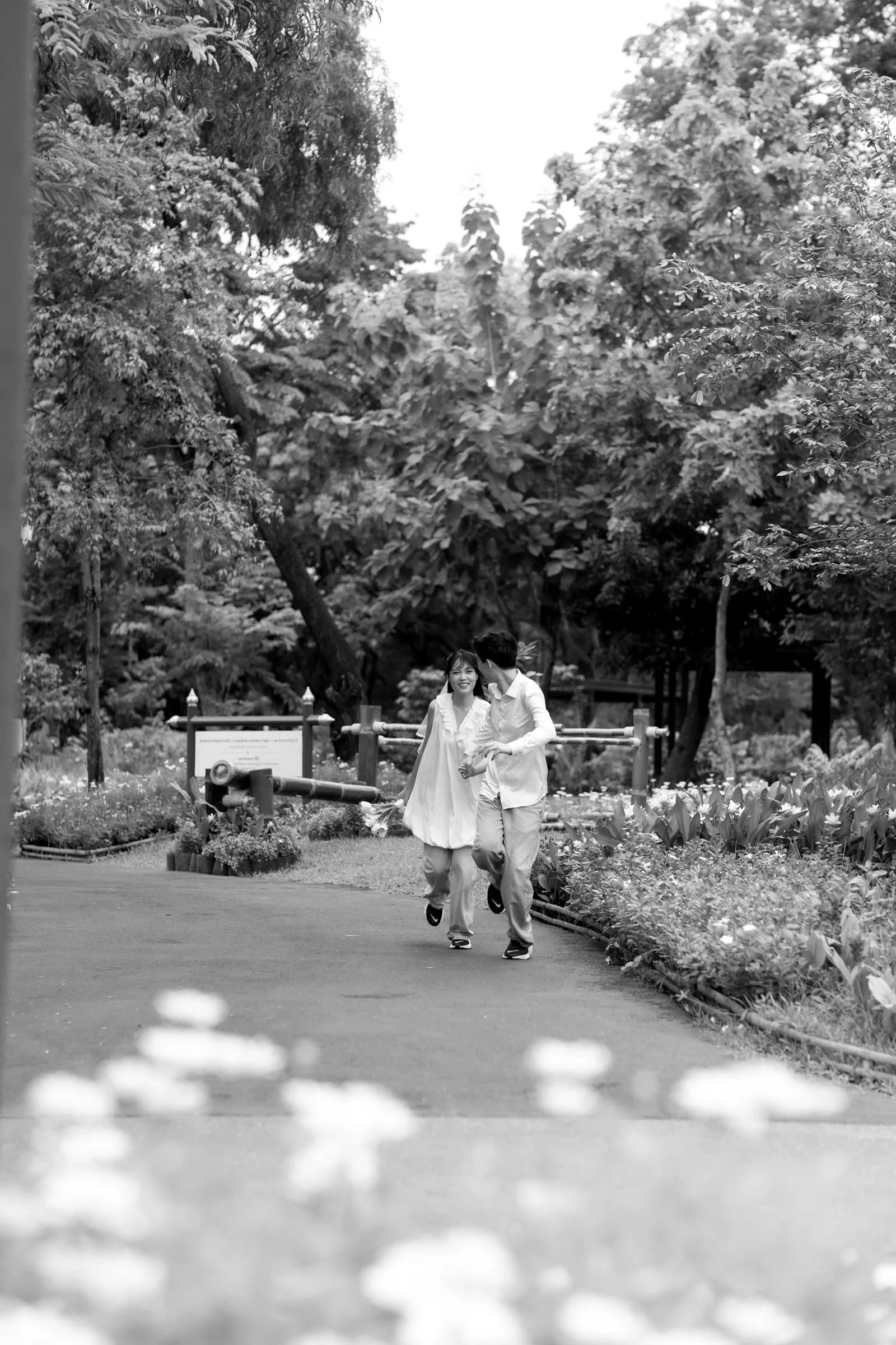 Natthida and Tanakan running together through the garden