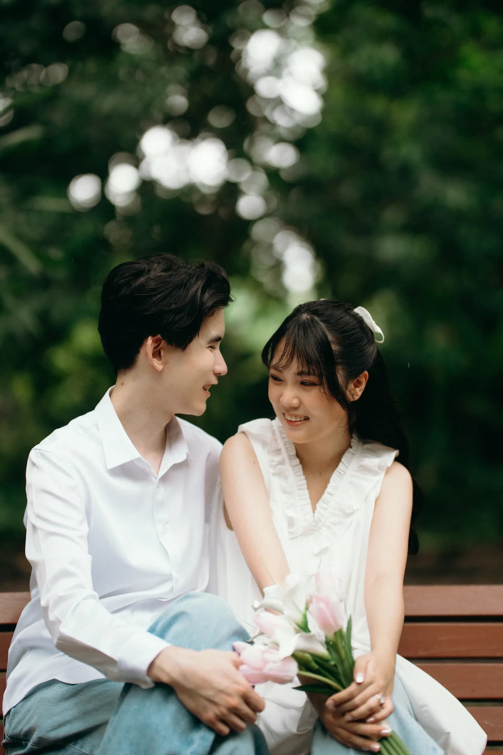 Natthida and Tanakan sitting together on a garden bench