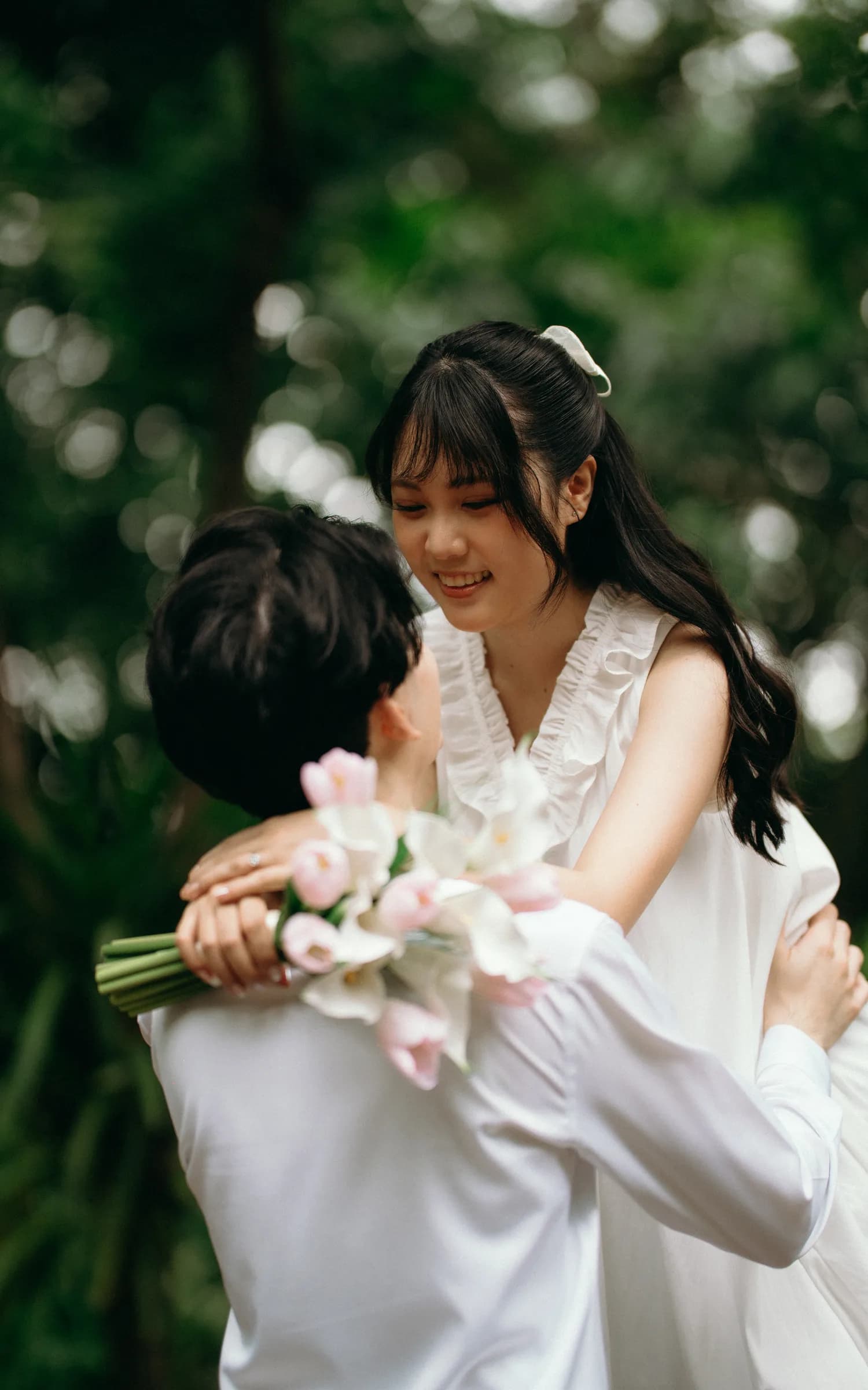Natthida smiling at Tanakan as he lifts her among the trees