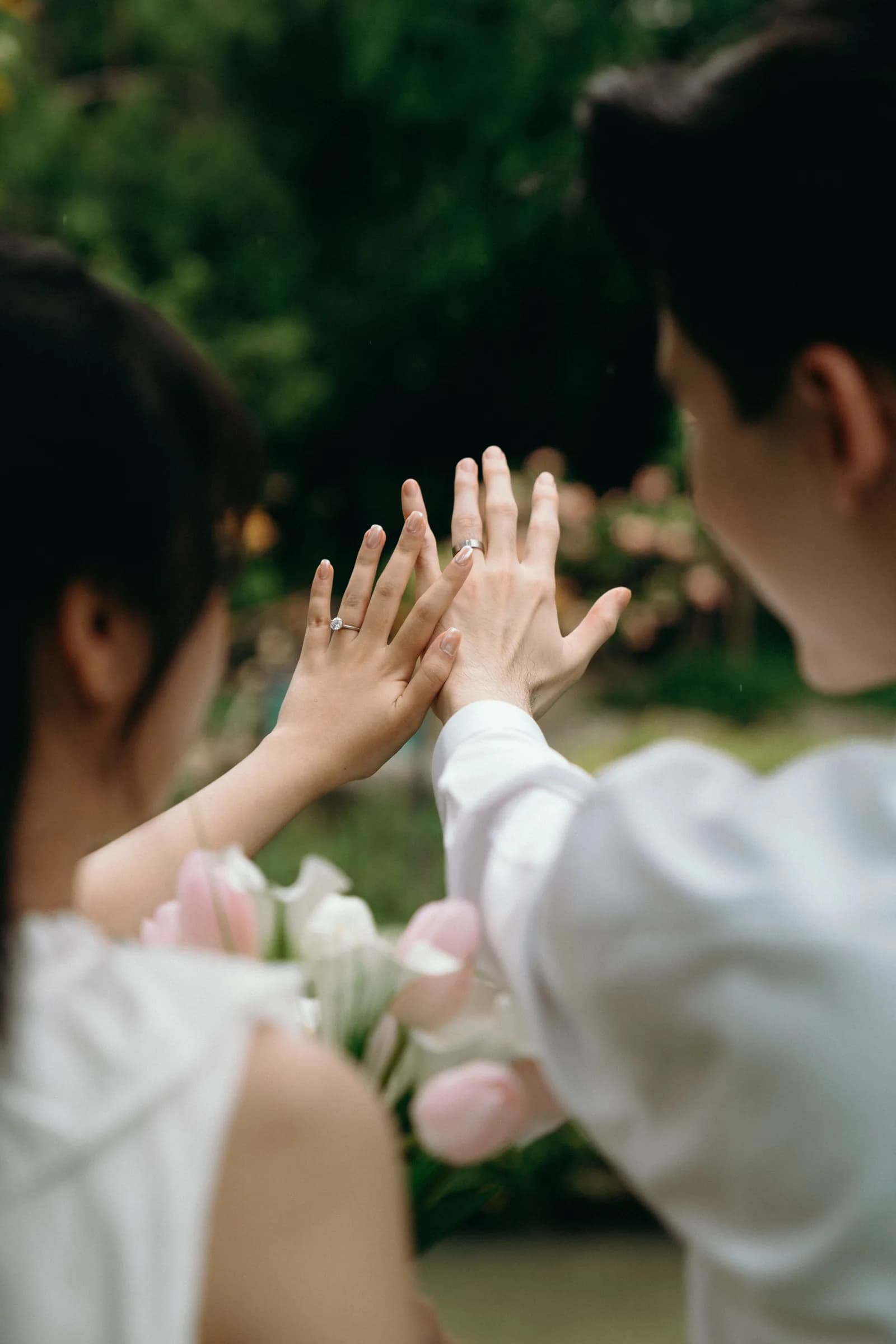 Natthida and Tanakan holding up their wedding rings